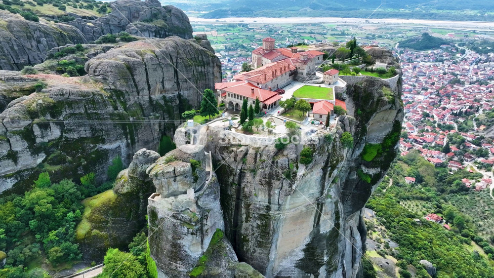 Aerial drone footage orbiting the Monastery of the Holy Trinity in Meteora, Greece. Cinematic close-up of the iconic UNESCO World Heritage site perched on a dramatic cliff rock