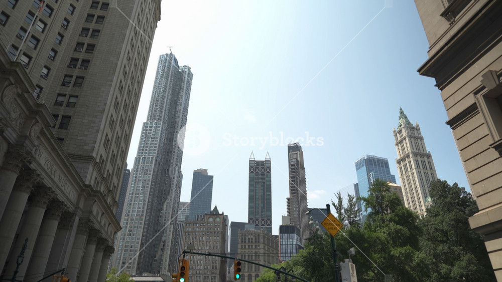 Mix of historic and contemporary architecture in the Financial District of New York City. Towering landmarks stand tall against a clear sky.