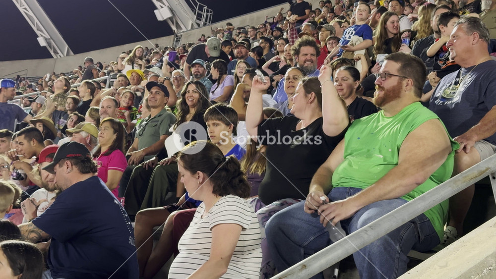 Orlando, Florida, USA - 03. 02. 2024: A large crowd of spectators watches and cheers during a live stadium event. People of different ages