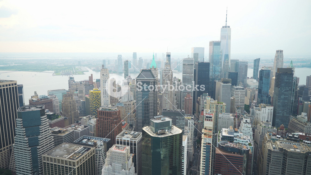 A striking aerial view of Lower Manhattan's skyscrapers, dominated by the towering One World Trade Center. The scene highlights New York