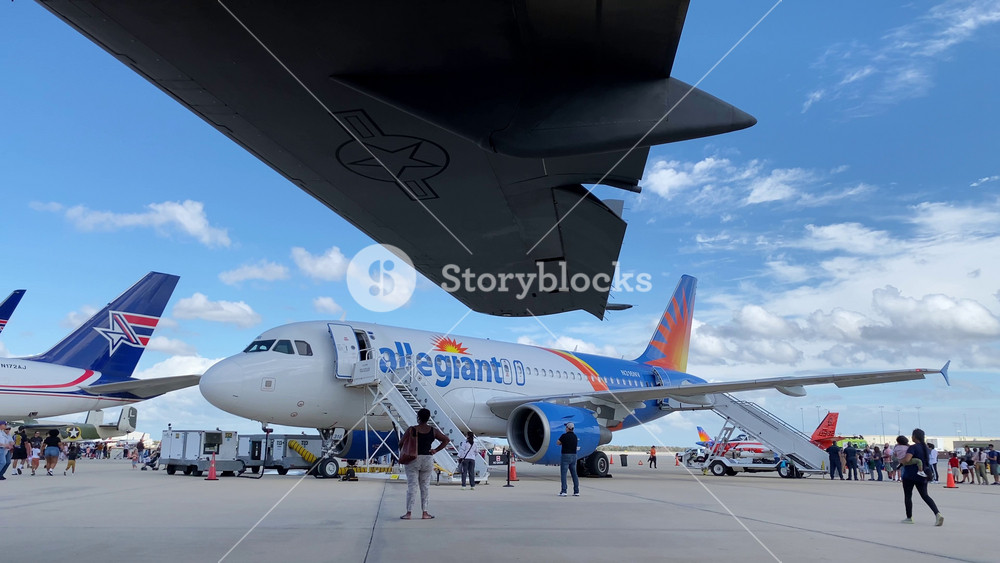 Orlando, Florida, USA - 01. 27. 2024: Several commercial jets stand on the airport tarmac with a crowd of visitors. Engines, wings and