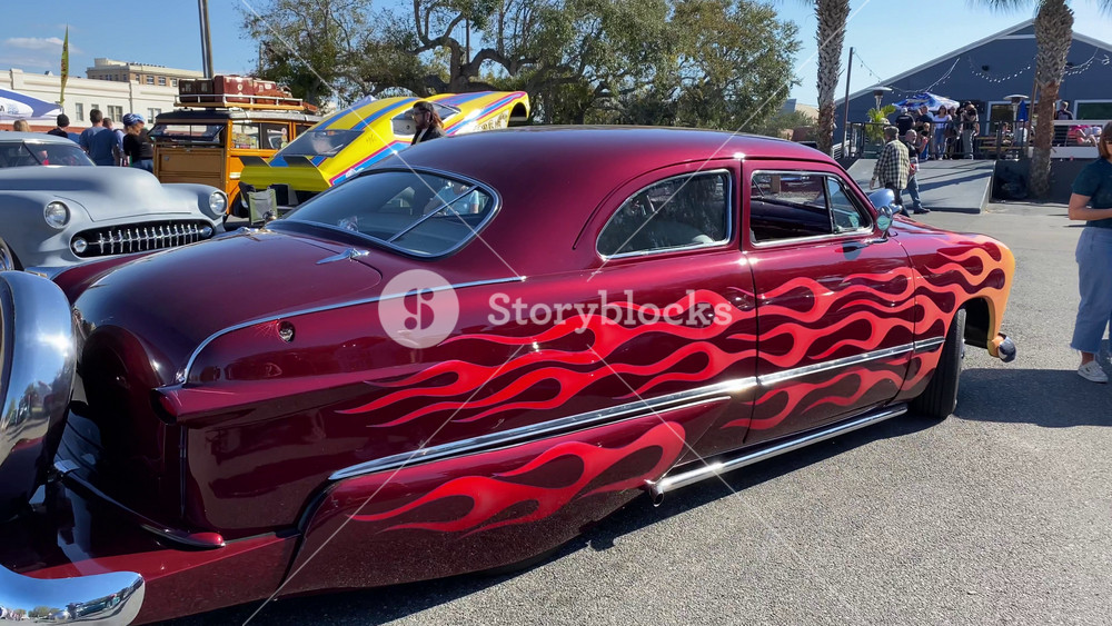 Orlando, Florida, USA - 02. 03. 2024: A flame painted 1951 Ford Custom is parked among other vintage cars at a classic car show. The custom