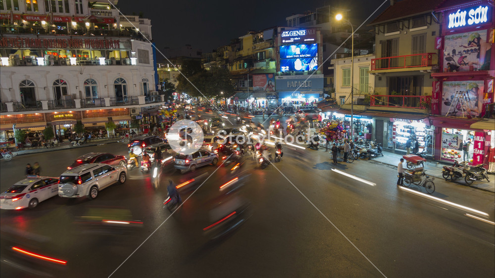 HANOI, VIETNAM 28 NOVEMBER 2015: Night time lapse of motorbikes and other traffic driving on busy intersection in historic center Hanoi, transport and infrastructure in Vietnam