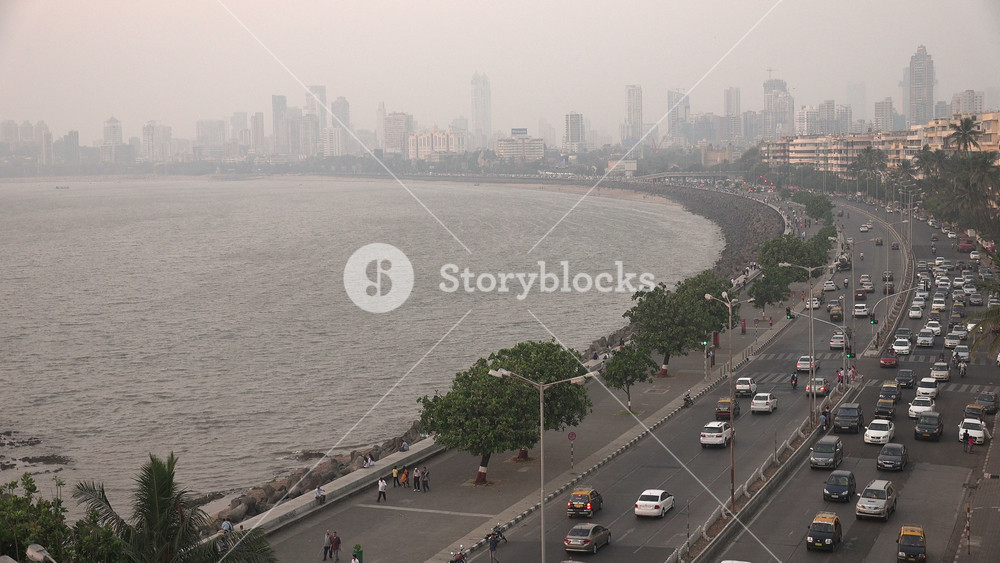 MUMBAI, INDIA NOVEMBER 2014: Traffic drives across Marine Drive in Mumbai, with city skyline in background, urban landscape and travel in India
