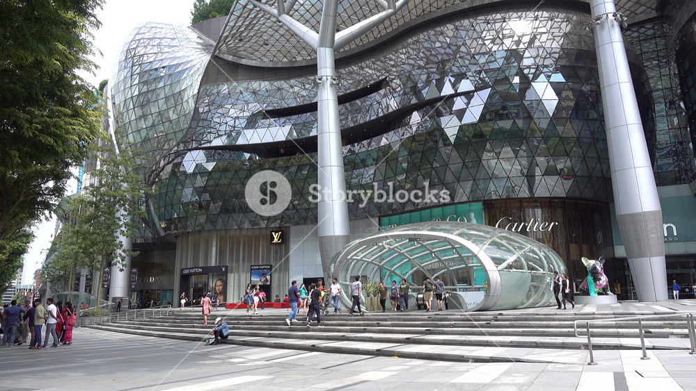 SINGAPORE MAY 2017: Pedestrians walk past massive futuristic Ion Orchard shopping mall in downtown Singapore, economy and commerce in Southeast Asia