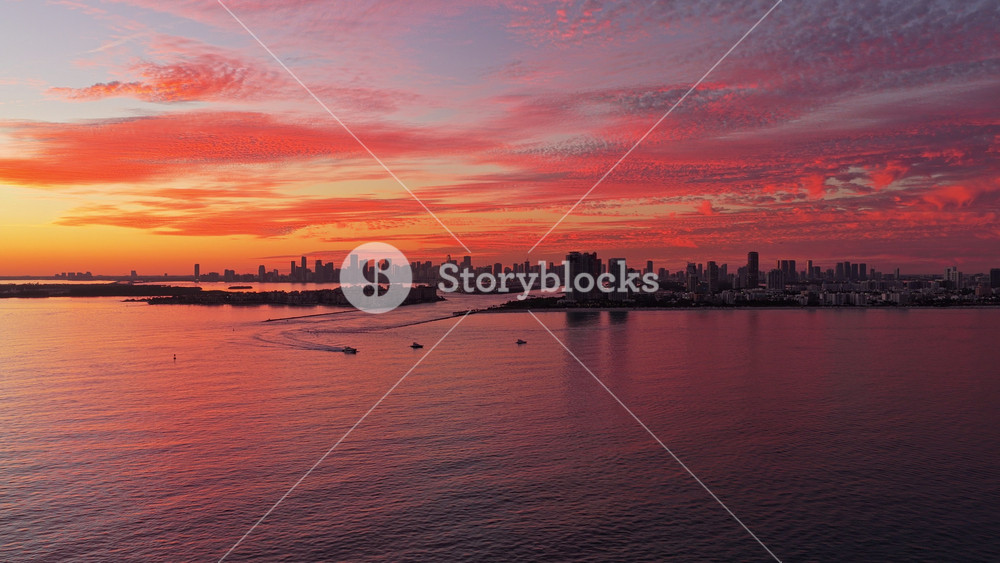 Sunset dramatic sky Miami city. Seascape with cityscape on sunset. Night cityscape of Miami with sea and dramatic sky. Miami sunset aerial