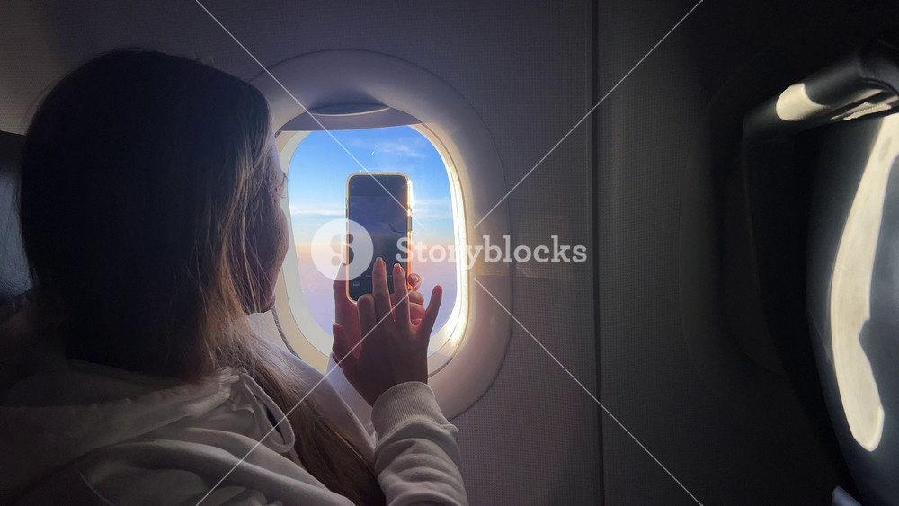 Traveler takes photos of aerial landscapes and glowing cabin lighting with a smartphone, showing a modern explorer documenting the beauty of