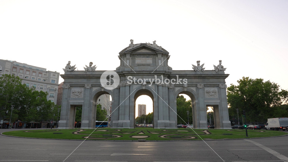 Sunrise Timelapse Puerta de Alcala Madrid, Spain. Fast Moving, Slow Zoom Out Landmark Archway. Traffic Cars Drive Through Busy European City