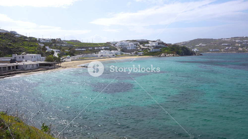 Mykonos Greece Beautiful Wide View of Beach Aegean Sea with White Houses in the Distance. Perfect Greek Island Vacation Holiday Travel Tourism.
