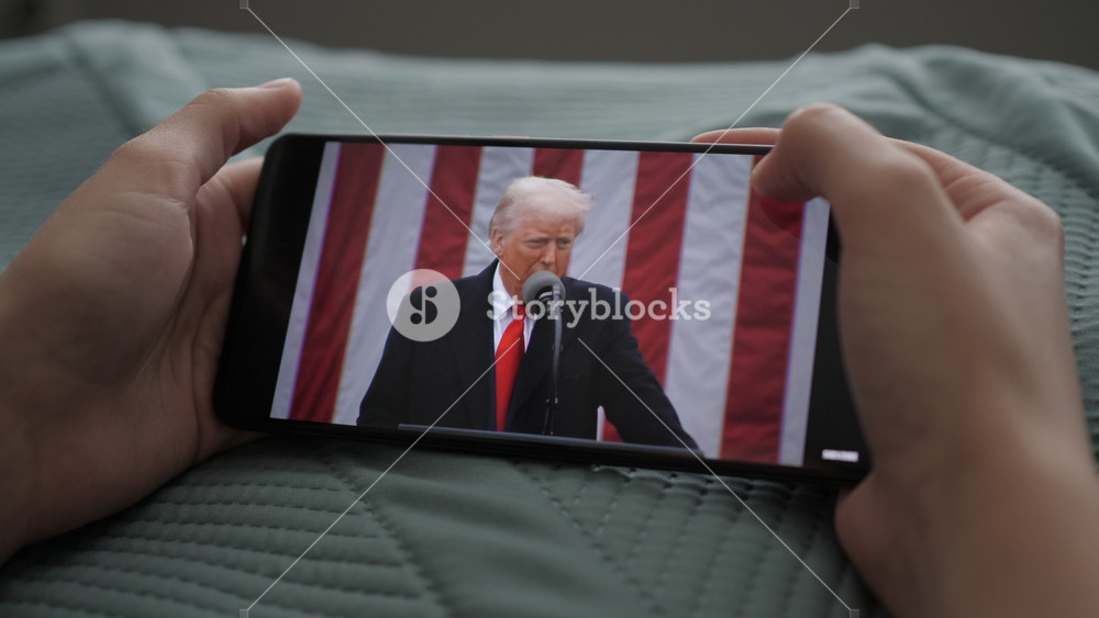 Person Watches US President Donald Trump's Speech at White House on His Mobile Phone. President Trump Holds "Make America Wealthy Again Event" In White House. Greer, SC, USA - August 03, 2025.