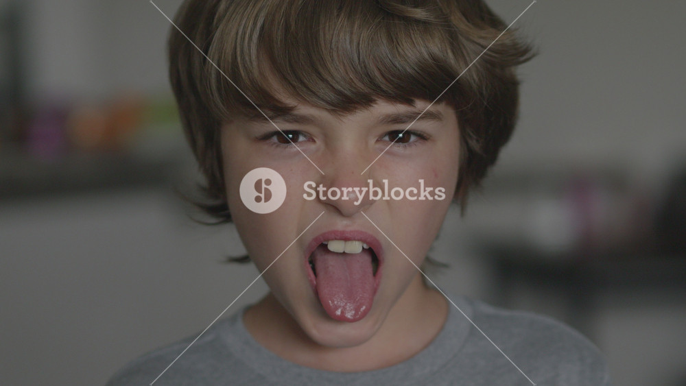 Young Boy Showing Tongue Making Fooling Around, Teasing. Tongue Out Child Grimacing Kid. Angry Boy Shows Her Tongue in Funny Grimace. Bad Behavior of Children.