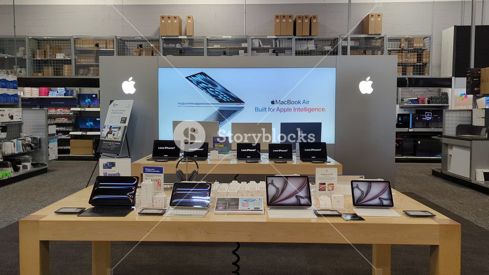 Interior of Apple Store With Customers. Customers Browsing, Trying and Buying Apple Products Displayed on Wooden Tables at an Apple Store. Greenville, SC, USA - August 30, 2025.