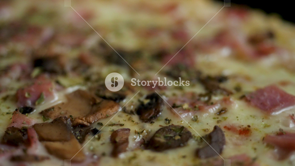 Close-up view of Freshly Prepared Pizza with Mozzarella Cheese, Bacon, Chicken, Tomatoes, Pepper, Mushrooms and Fresh Basil. Homemade Pizza, Junk food, Fast Food.