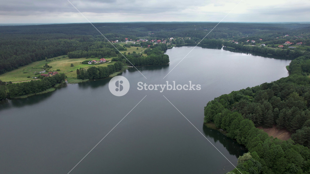 Forested Area With River Running Through it. Water is Calm and Clear. Trees Are Lush Sky is Cloudy. Dramatic Aerial View of Big Lake and Green Forest. Epic Amazing Nature Landscape Nature Reserve.
