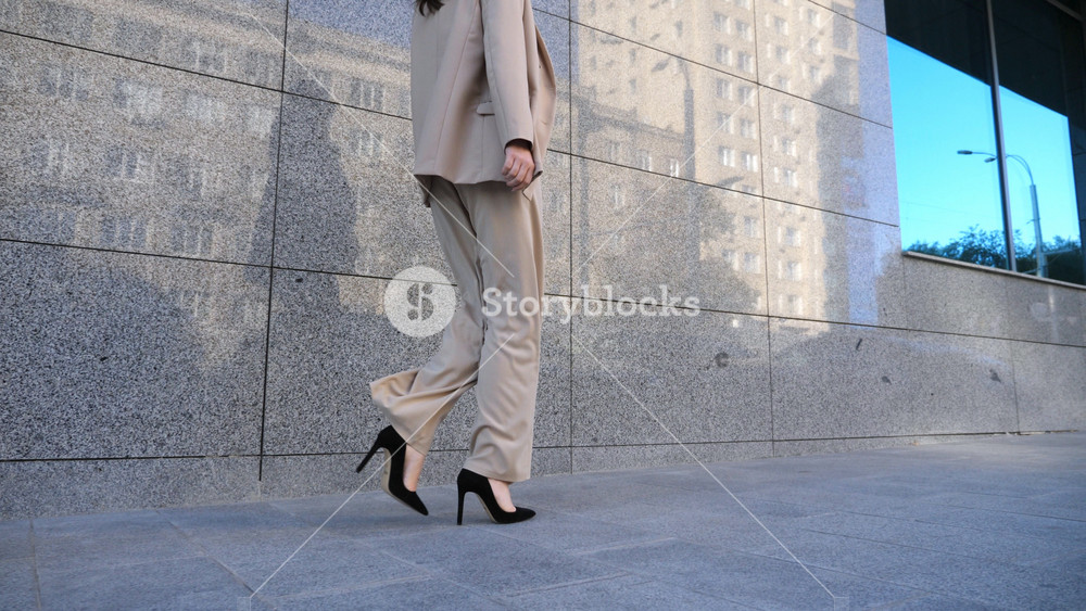 Young business woman going on city street to meeting in office. Confident businesswoman walking near modern building. Successful lady in formal wear commuting to work. Concept of career. Slow motion