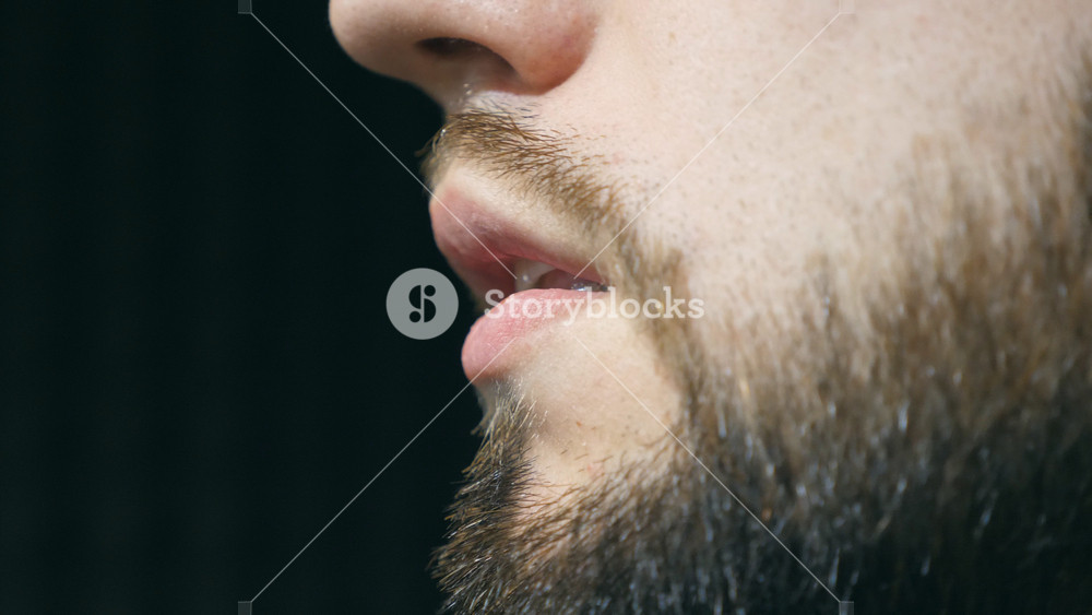 Mouth of male singer singing song at sound studio. Unrecognizable young man recording new melody or song. Working of creative musician. Show business concept. Slow motion.