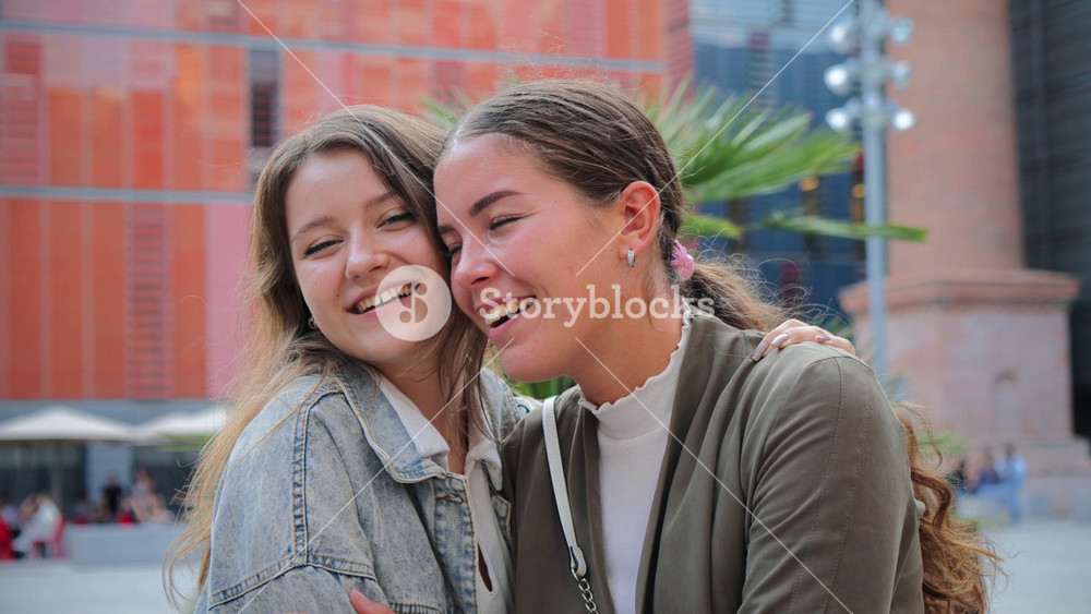 Joyful moment of affection between two female friends as one gives a sweet kiss on the cheek, sharing happiness, closeness, and friendship
