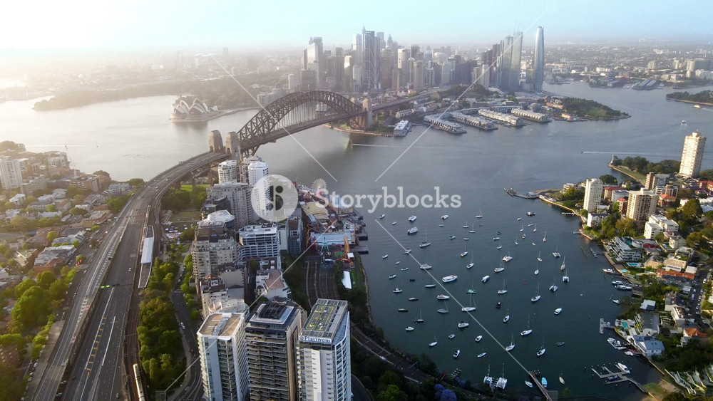 Aerial drone pullback reverse view of Sydney City, the Sydney Harbour and the Harbour Bridge above Lavender Bay, NSW Australia in the early morning in November 2023