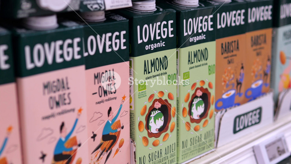Warsaw, Poland - May 01, 2024: Colorful almond and oat milk cartons showcasing product range, arranged neatly on grocery store shelf with